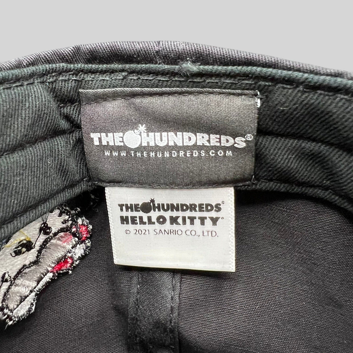 Raree Finds The Hundreds x Hello Kitty collaboration cap interior tags showing official Sanrio 2021 branding