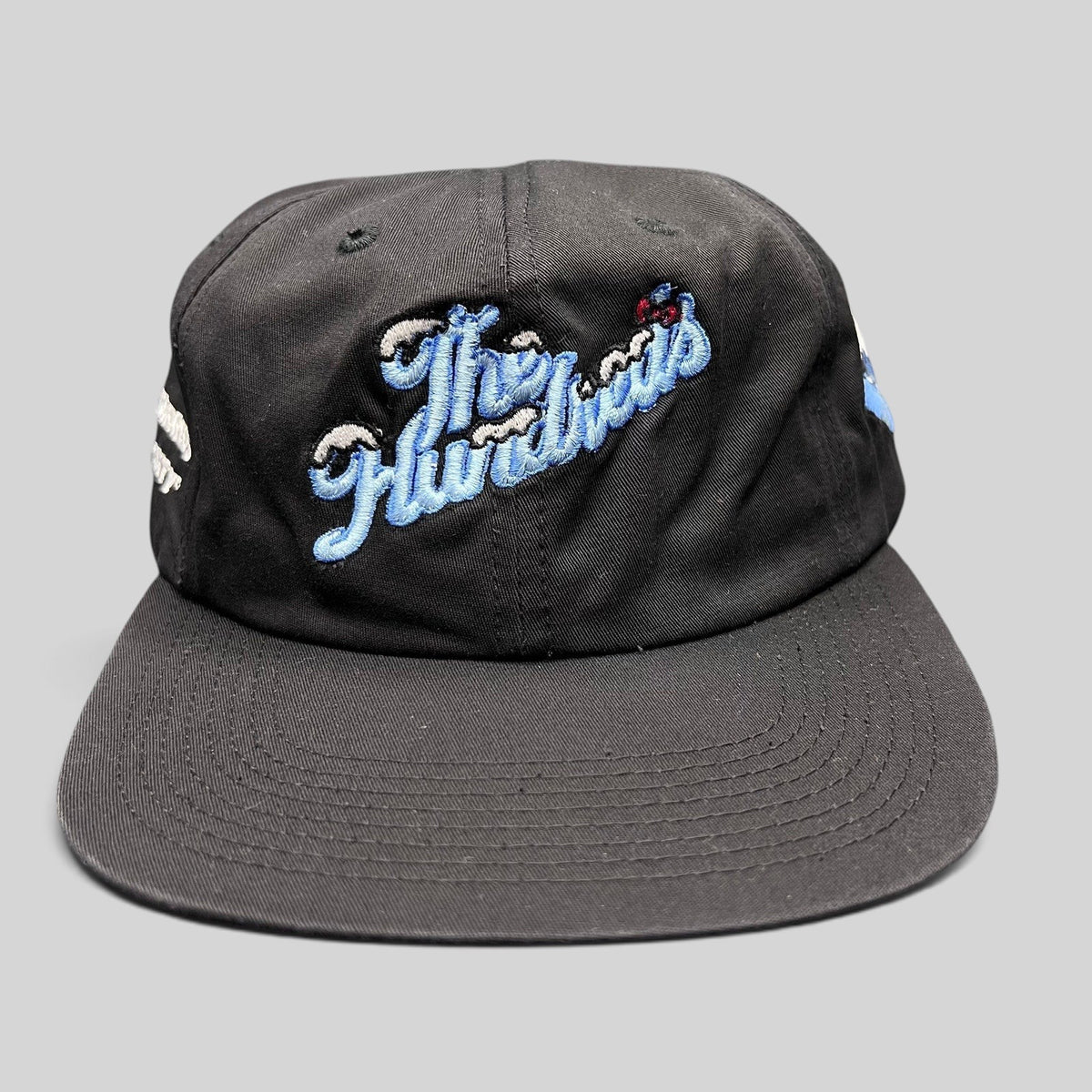 Raree Finds black cotton snapback hat from The Hundreds x Hello Kitty 2021 collaboration with blue embroidered script.
