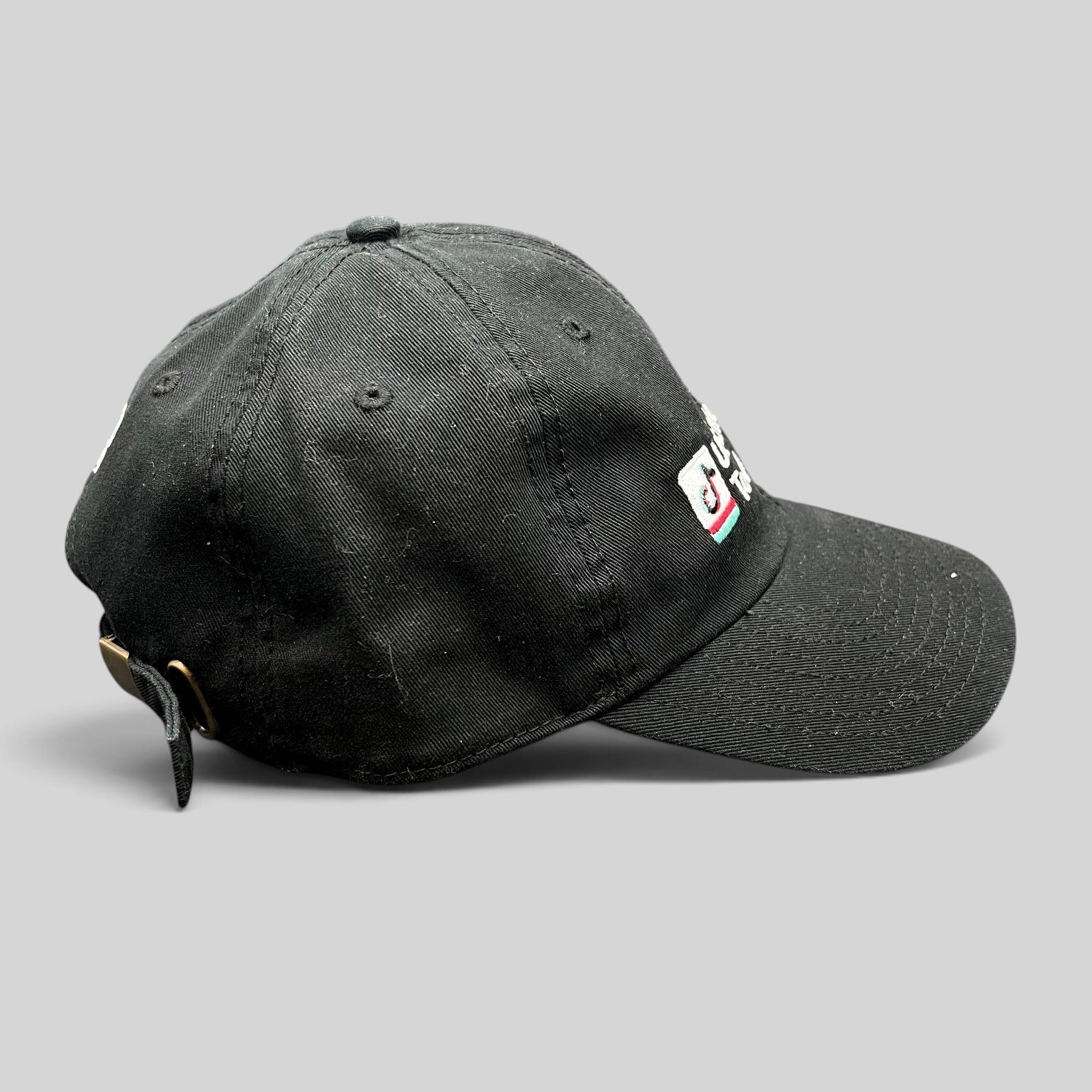 Raree Finds black TikTok US Enterprise Team strapback hat with embroidered logo and brass buckle side profile view