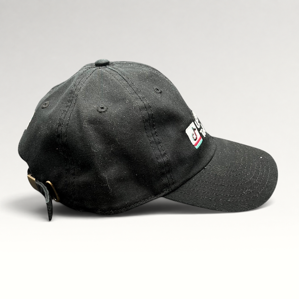 Raree Finds black TikTok US Enterprise Team strapback hat with embroidered logo and brass buckle side profile view