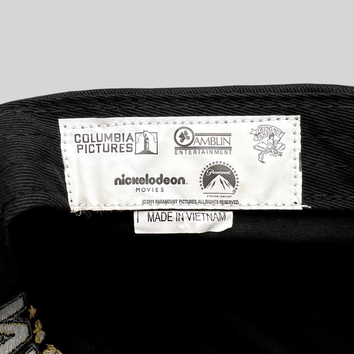 Raree Finds black 5-panel hat interior tag featuring Columbia, Amblin, WingNut, Nickelodeon, and Paramount logos.