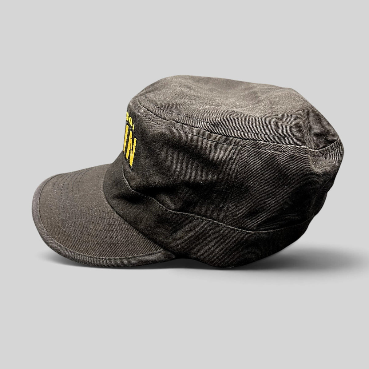 Raree Finds black 5-panel strapback hat with yellow embroidered The Adventures of Tintin logo, side view.