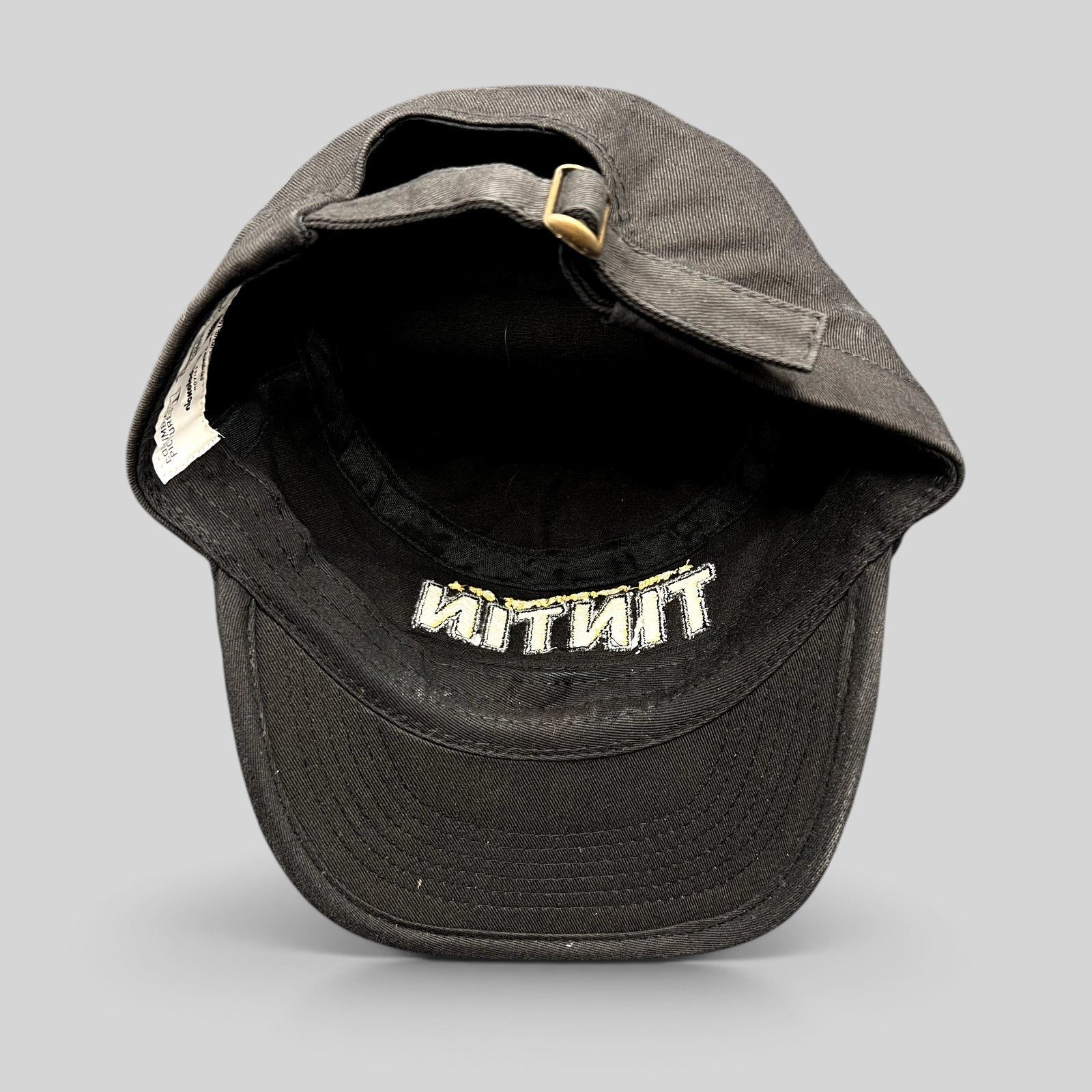 Raree Finds black 5-panel strapback hat from The Adventures of Tintin 2011 movie with brass buckle and interior tag