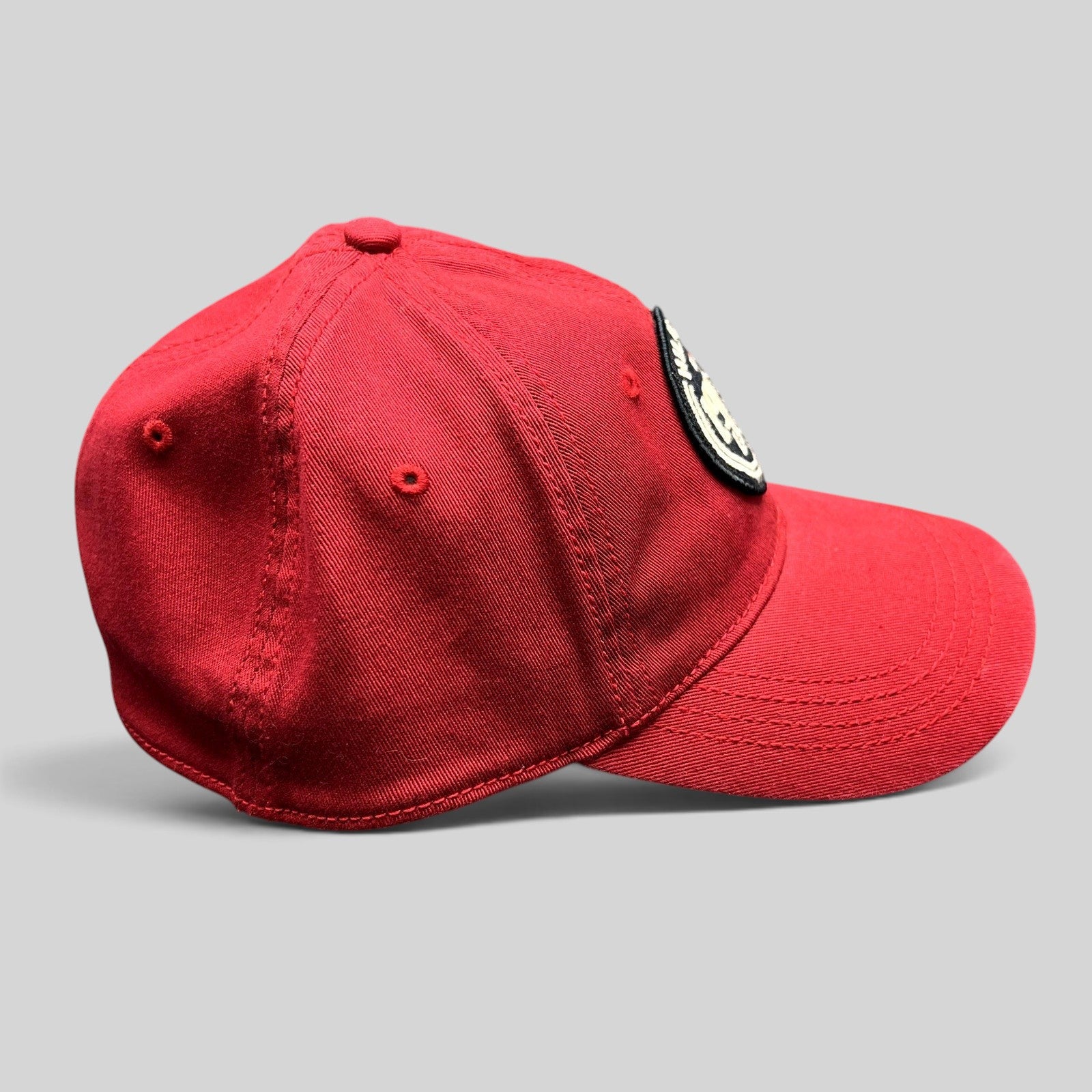 Raree Finds Tommy Hilfiger red fitted cap with 1985 EST circular patch and curved brim, side profile view.