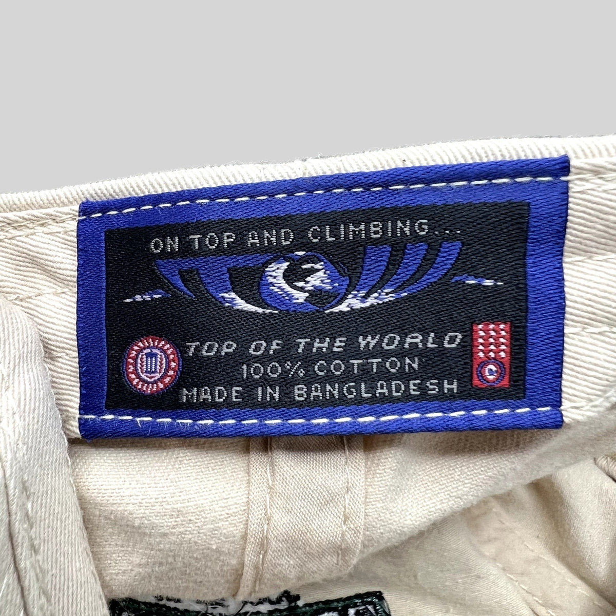 Raree Finds Top of the World cream cotton hat interior label with blue branding and manufacturing details