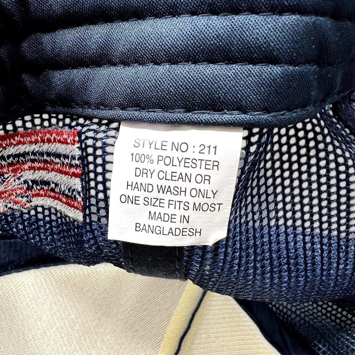 Raree Finds vintage trucker hat interior care label showing 100% polyester material and Bangladesh origin