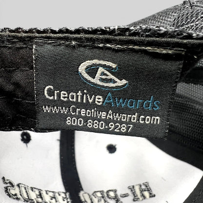 Raree Finds branded trucker hat interior tag showing Creative Awards manufacturer logo and contact information