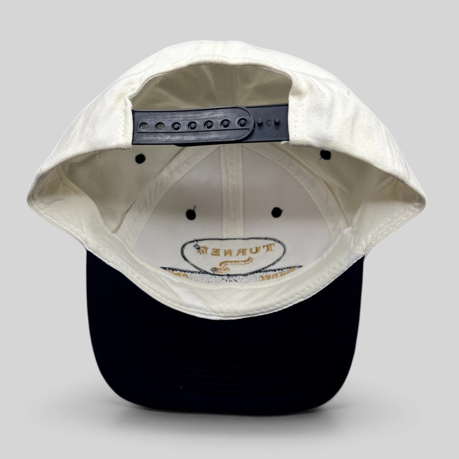 Raree Finds vintage Turner New Zealand snapback hat with white crown, navy brim, and adjustable plastic snap closure.