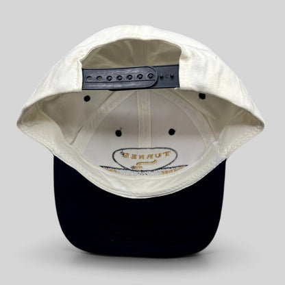 Raree Finds vintage Turner New Zealand snapback hat with white crown, navy brim, and adjustable plastic snap closure.