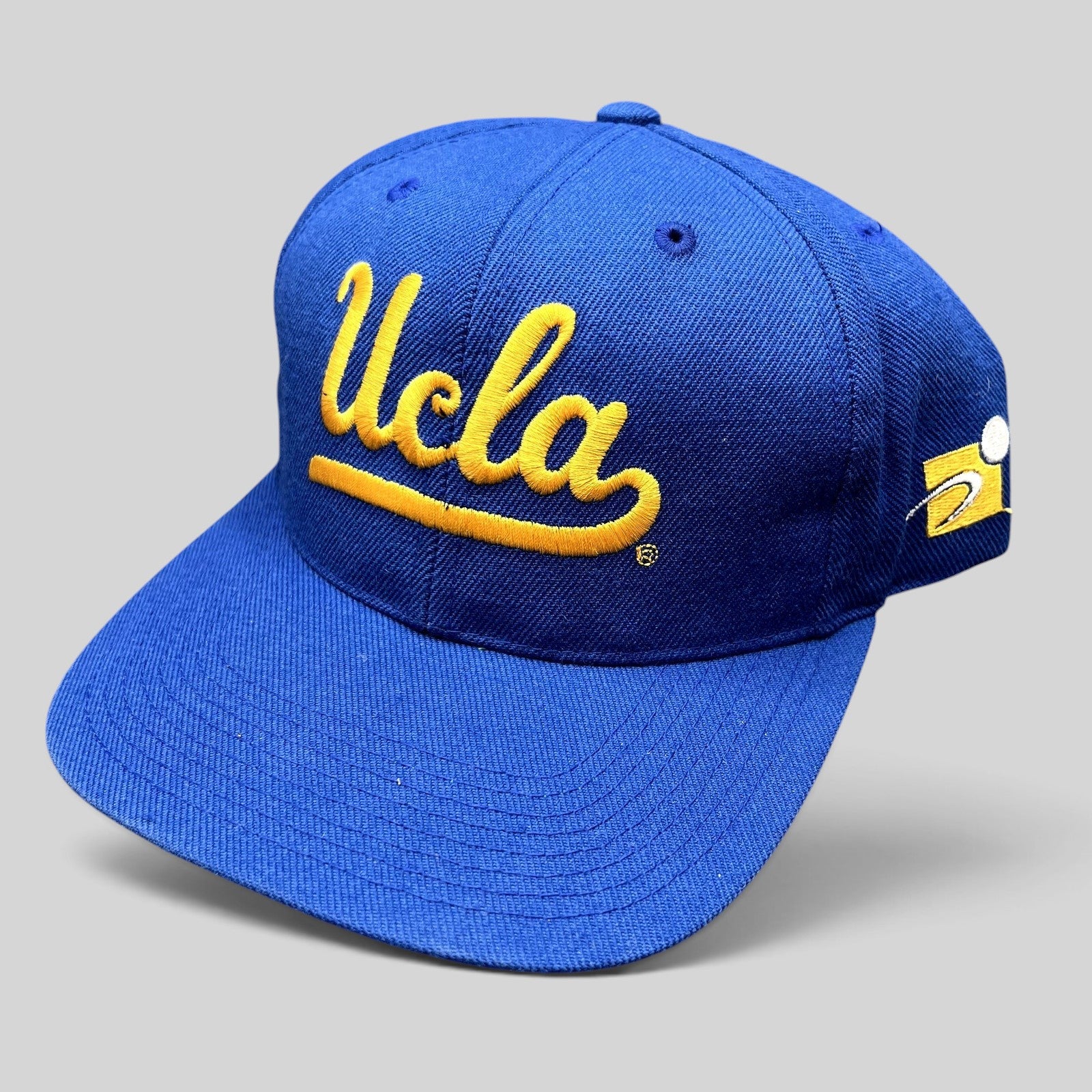 Raree Finds vintage UCLA Bruins royal blue snapback hat with gold script embroidery and green undervisor