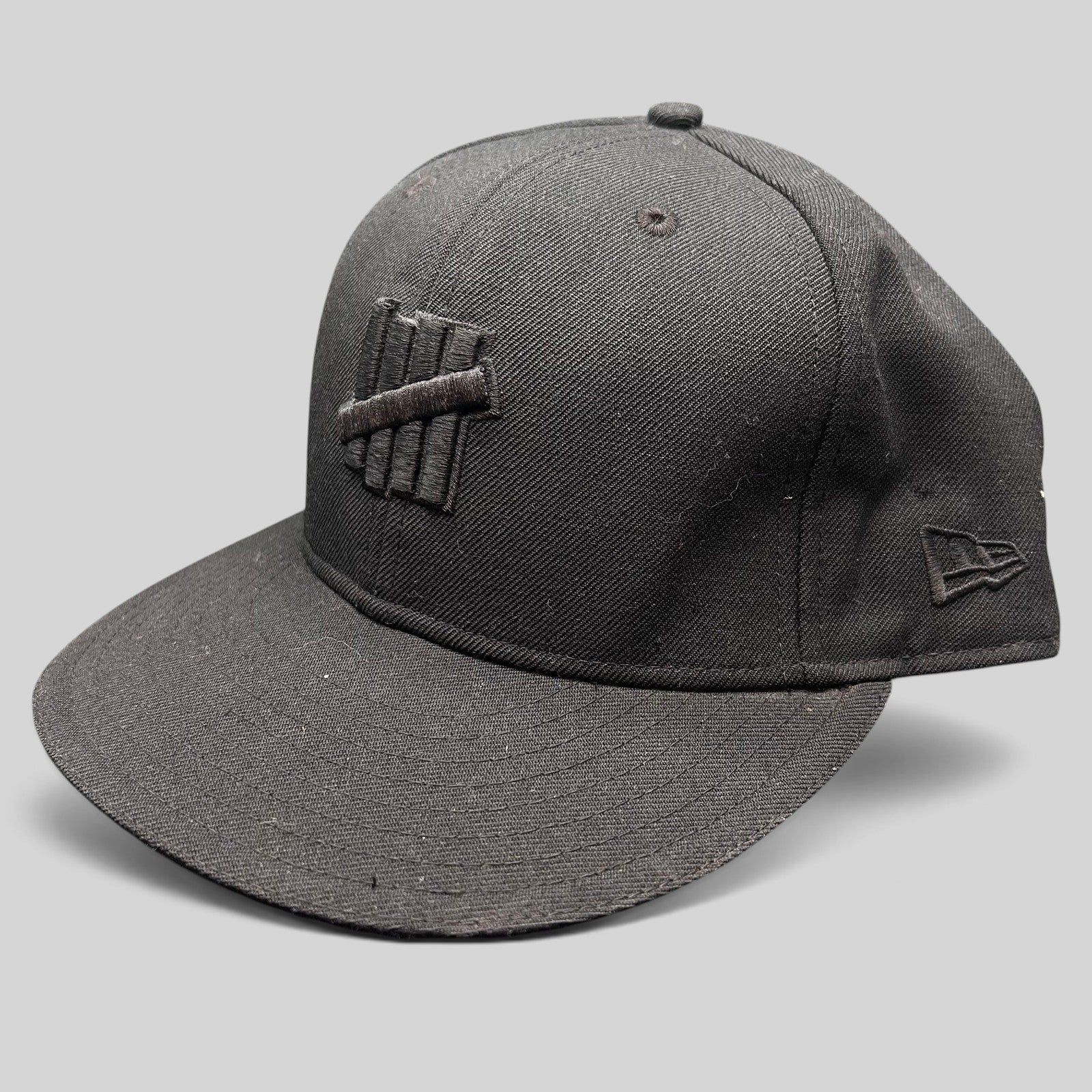 Raree Finds Undefeated 59FIFTY fitted hat in all black with tonal Five Strike logo embroidery and New Era side detail.