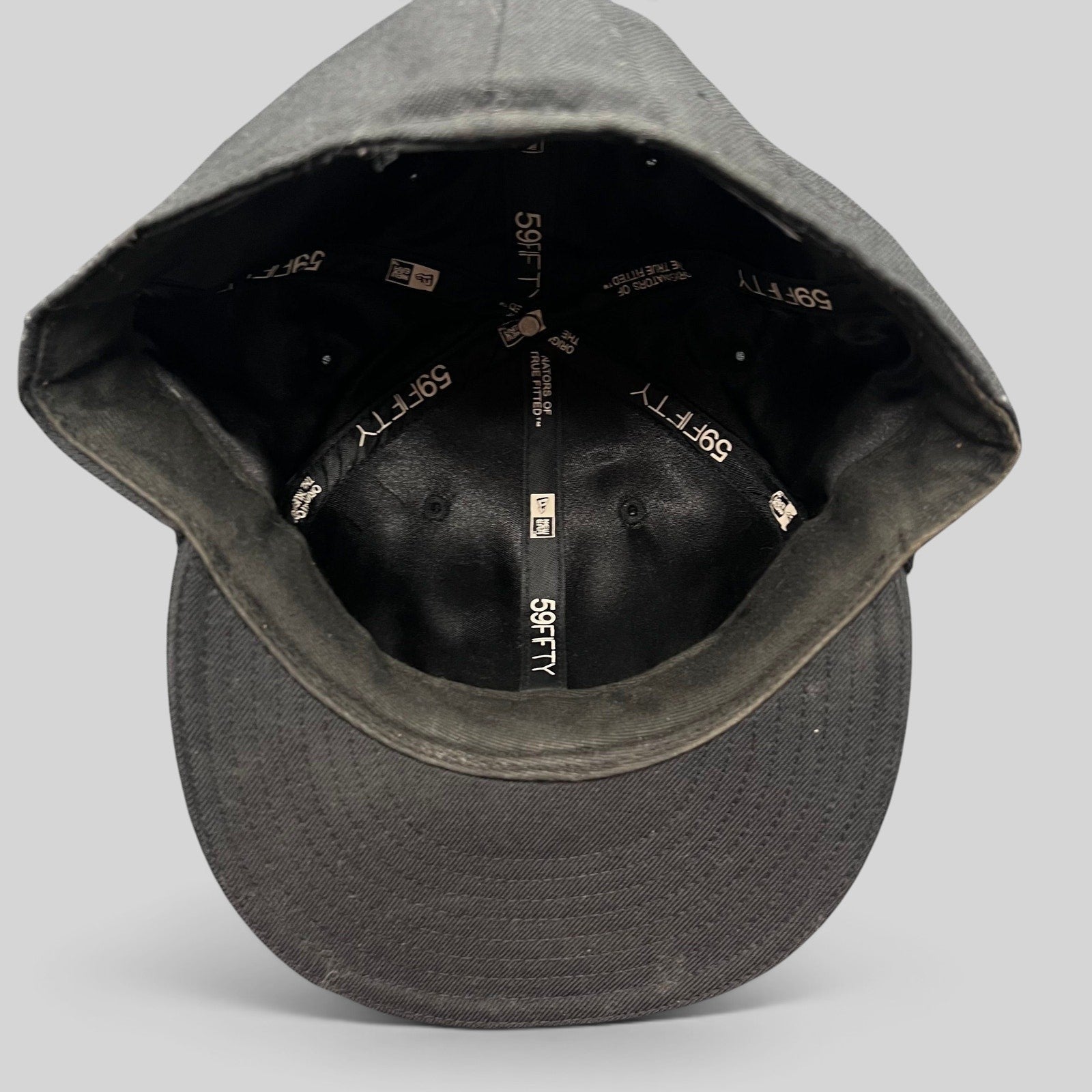 Raree Finds Undefeated New Era 59FIFTY fitted hat interior showing branded taping and structured crown construction