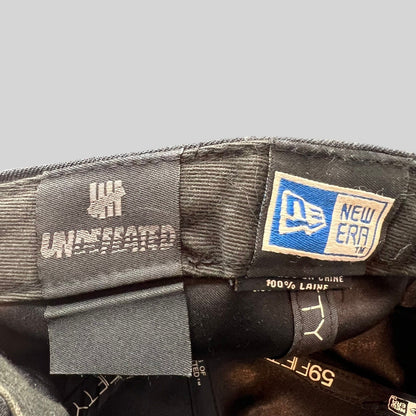 Raree Finds Undefeated New Era 59FIFTY wool cap interior tags showing brand logos and 100 percent wool material