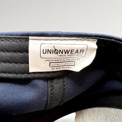 Raree Finds Unionwear interior tag on a navy blue cotton campaign hat made in the USA by Workers United