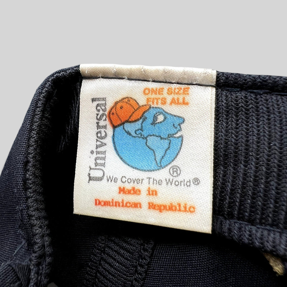 Raree Finds vintage Universal Industries hat interior tag showing globe logo and Made in Dominican Republic text