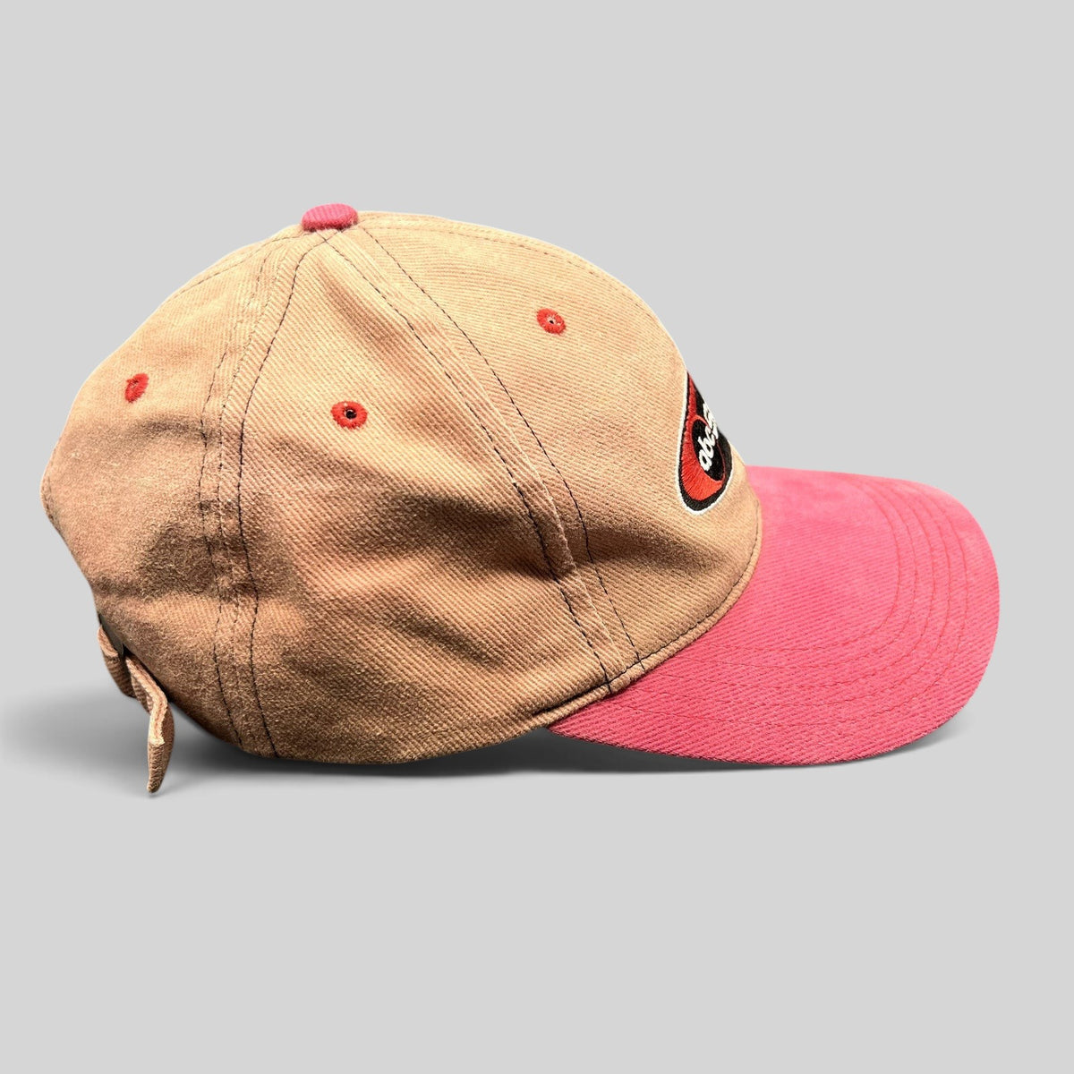 Raree Finds vintage ABC Sports strapback hat with a tan crown, pink brim, and embroidered logo in a side profile view.