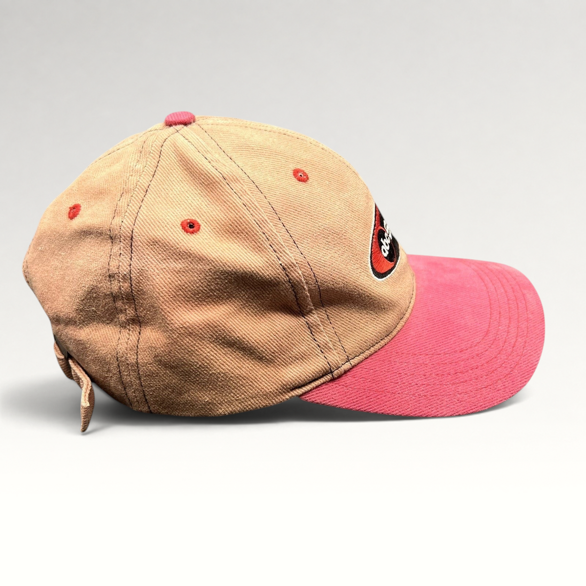 Raree Finds vintage ABC Sports strapback hat with a tan crown, pink brim, and embroidered logo in a side profile view.