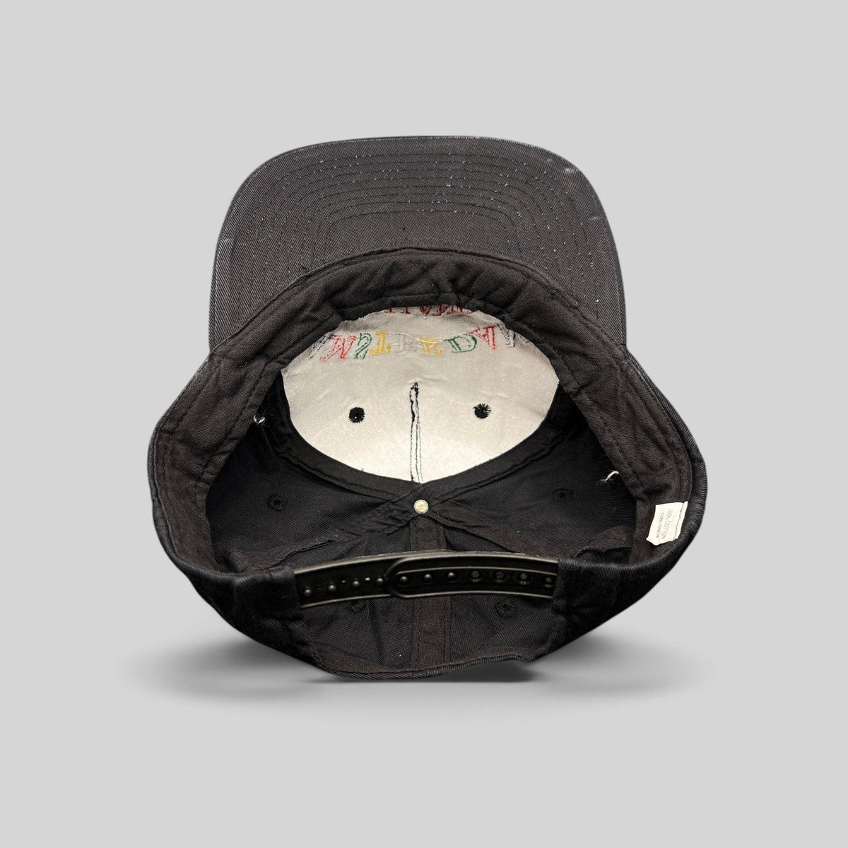 Raree Finds vintage 1990s Amsterdam Holland black cotton snapback hat, interior view showing plastic snap closure.