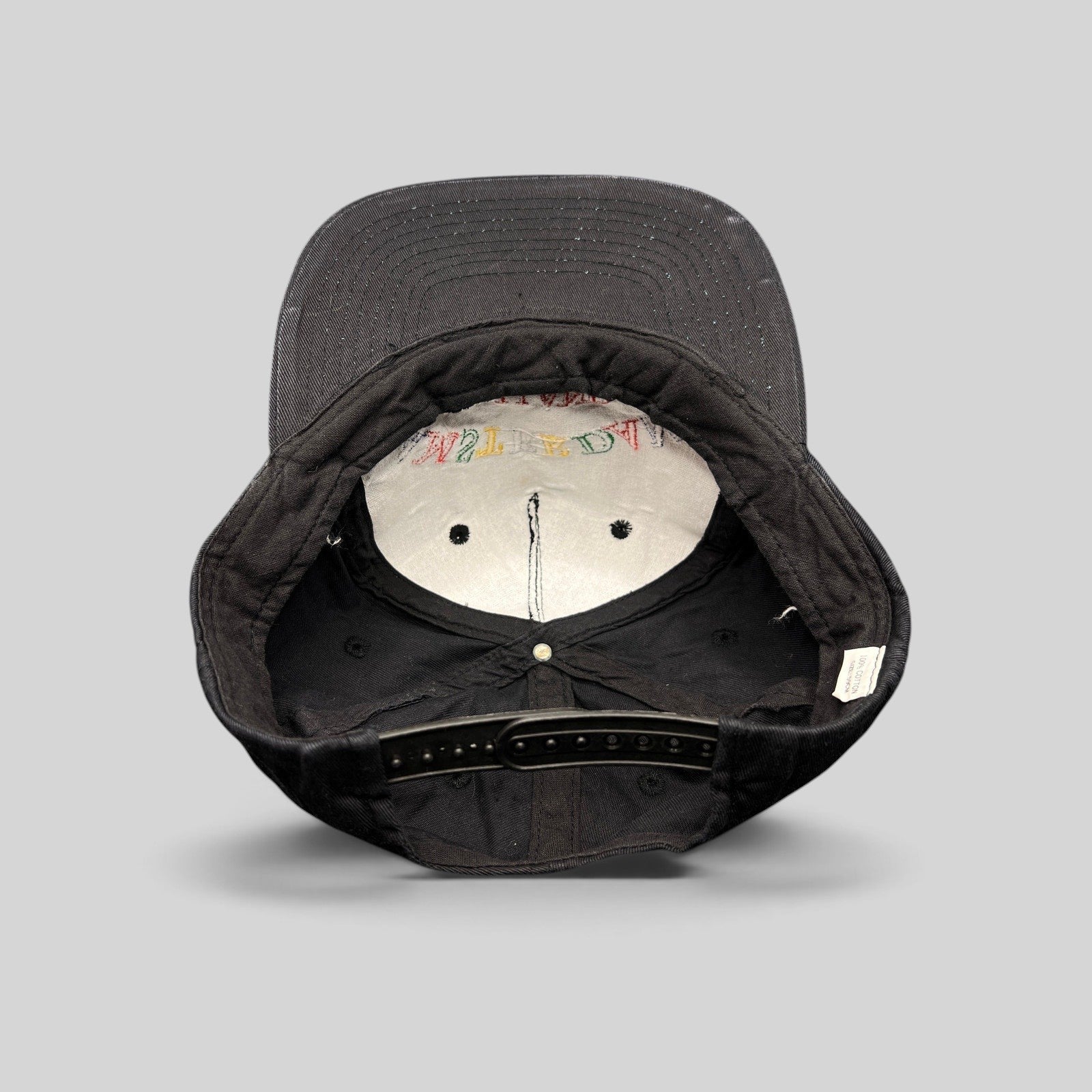 Raree Finds vintage 1990s Amsterdam Holland black cotton snapback hat, interior view showing plastic snap closure.