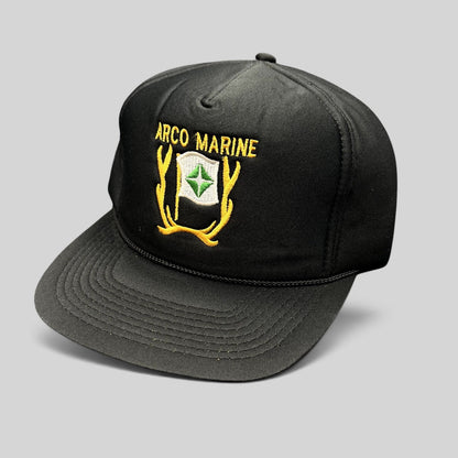 Raree Finds vintage black ARCO Marine snapback hat with yellow and green embroidered logo and black rope brim detail.