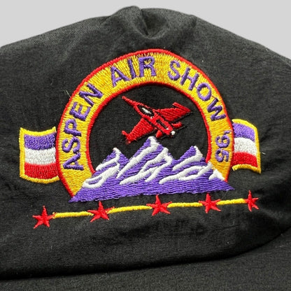 Raree Finds vintage 1995 Aspen Air Show black nylon snapback hat with embroidered red jet and purple mountain design.
