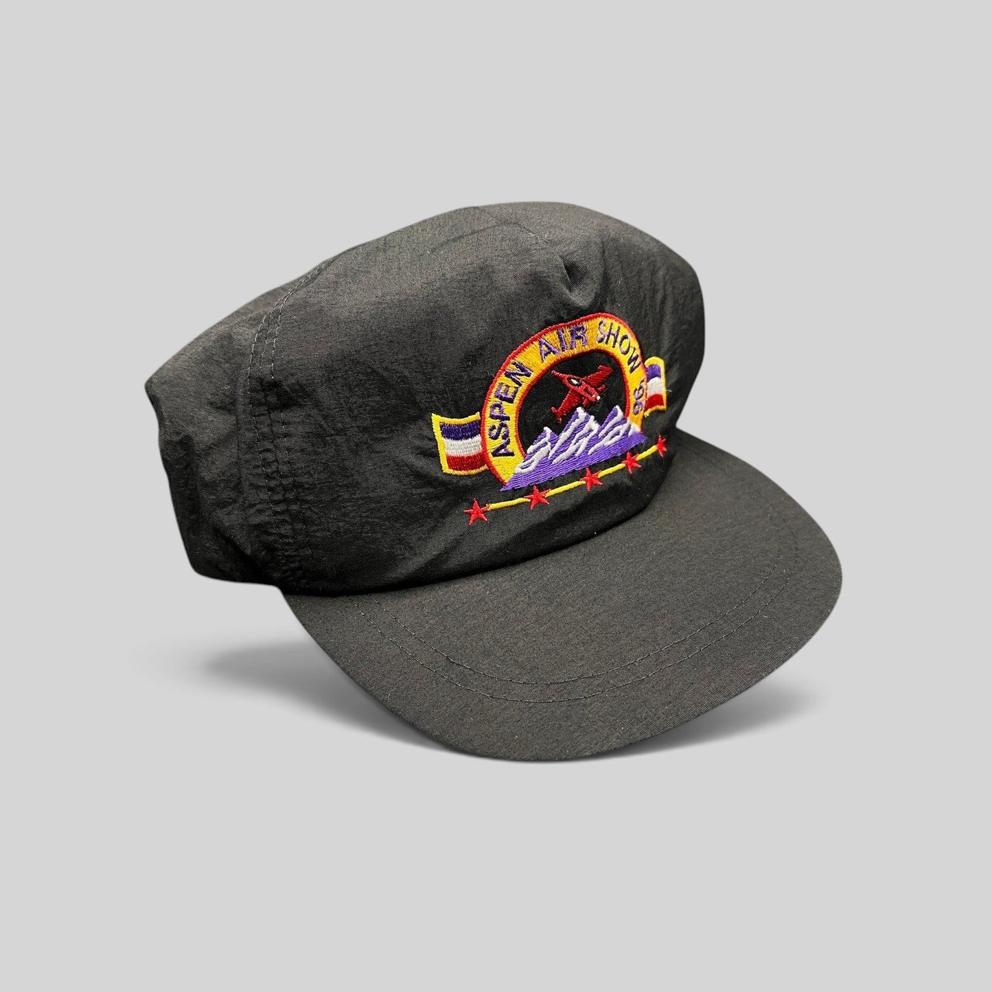 Raree Finds vintage 1995 Aspen Air Show black nylon snapback hat with multicolor jet and mountain embroidery