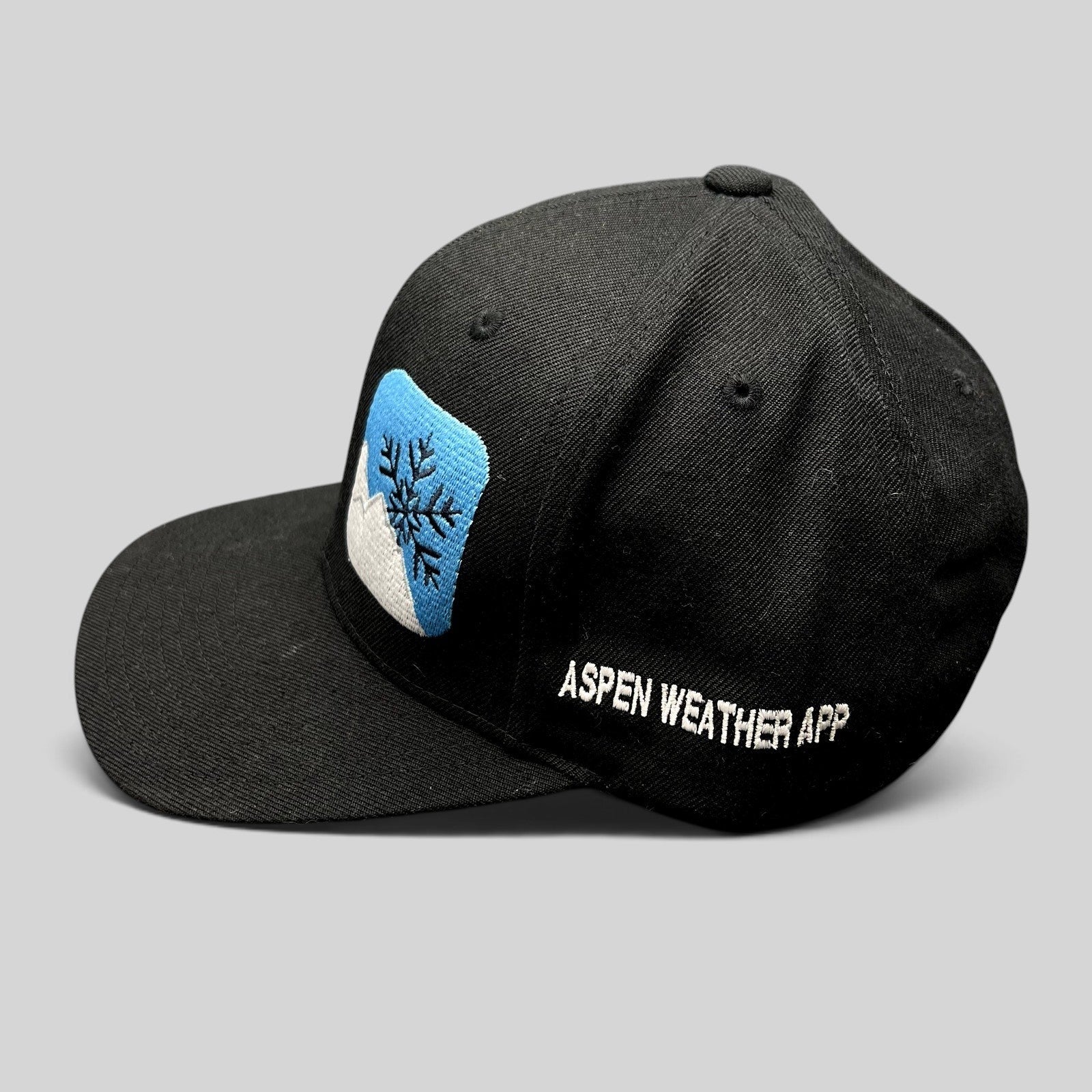 Raree Finds vintage black Yupoong snapback hat with embroidered mountain and snowflake logo and side text.
