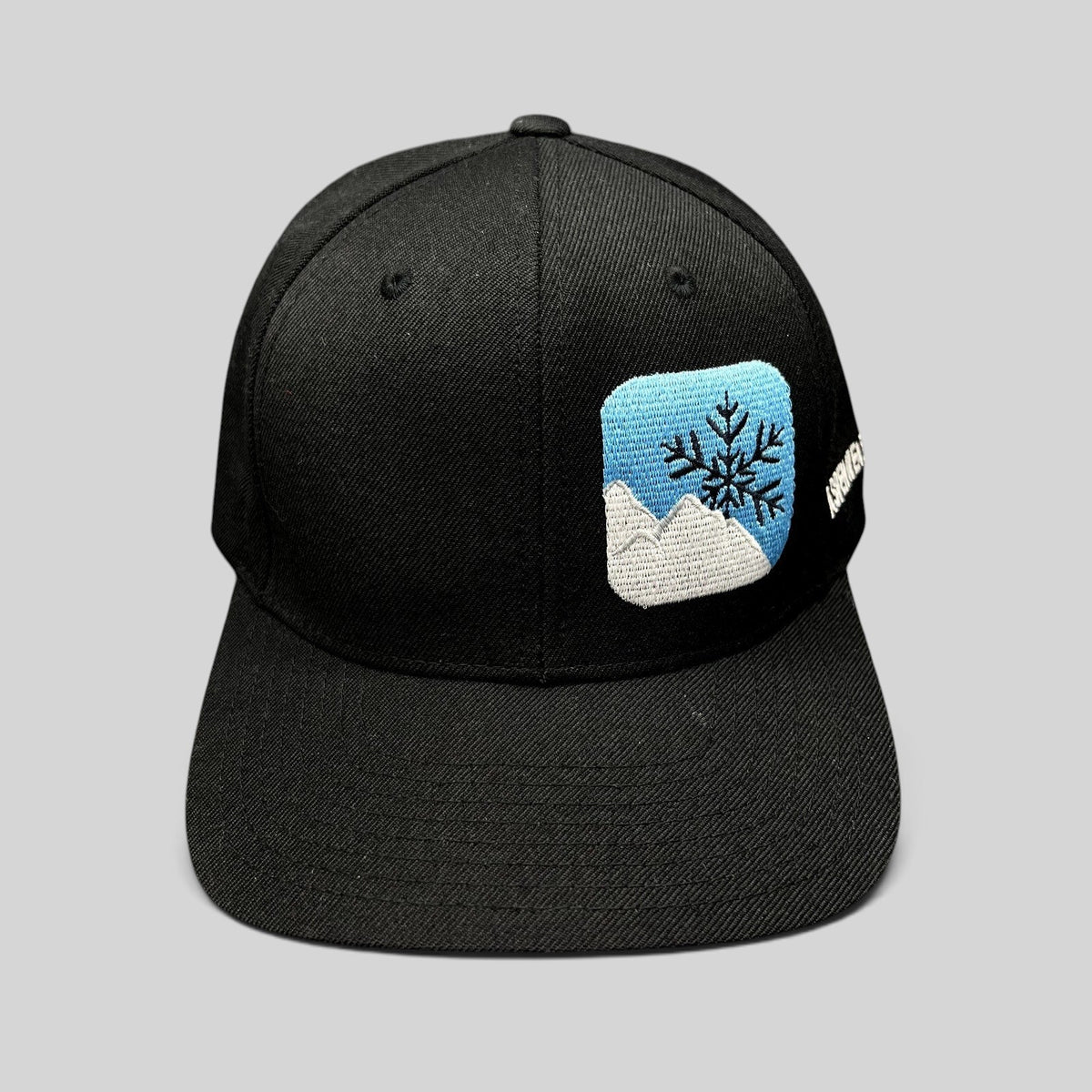 Raree Finds vintage black Yupoong snapback hat with embroidered mountain and snowflake logo and side text