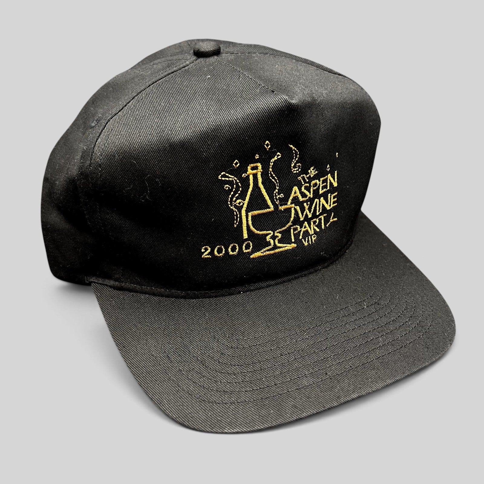 Raree Finds vintage 2000 Aspen Wine Party VIP black strapback hat with gold embroidered champagne bottle graphic