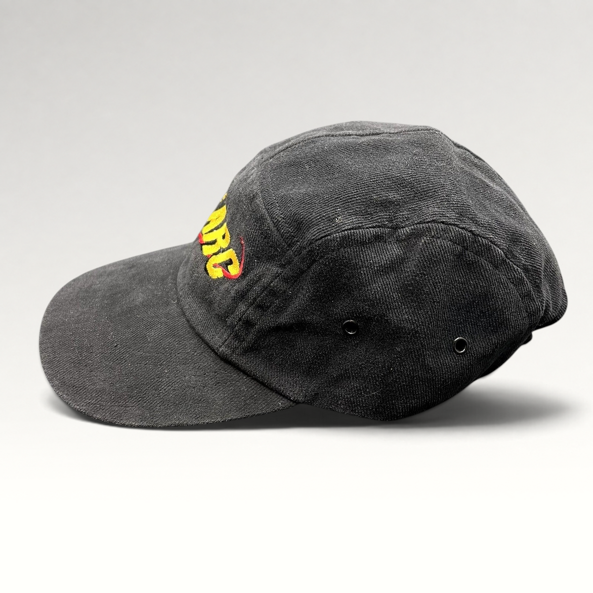 Raree Finds vintage black cotton Atomic ARC strapback hat with yellow and red embroidered logo, side profile view.