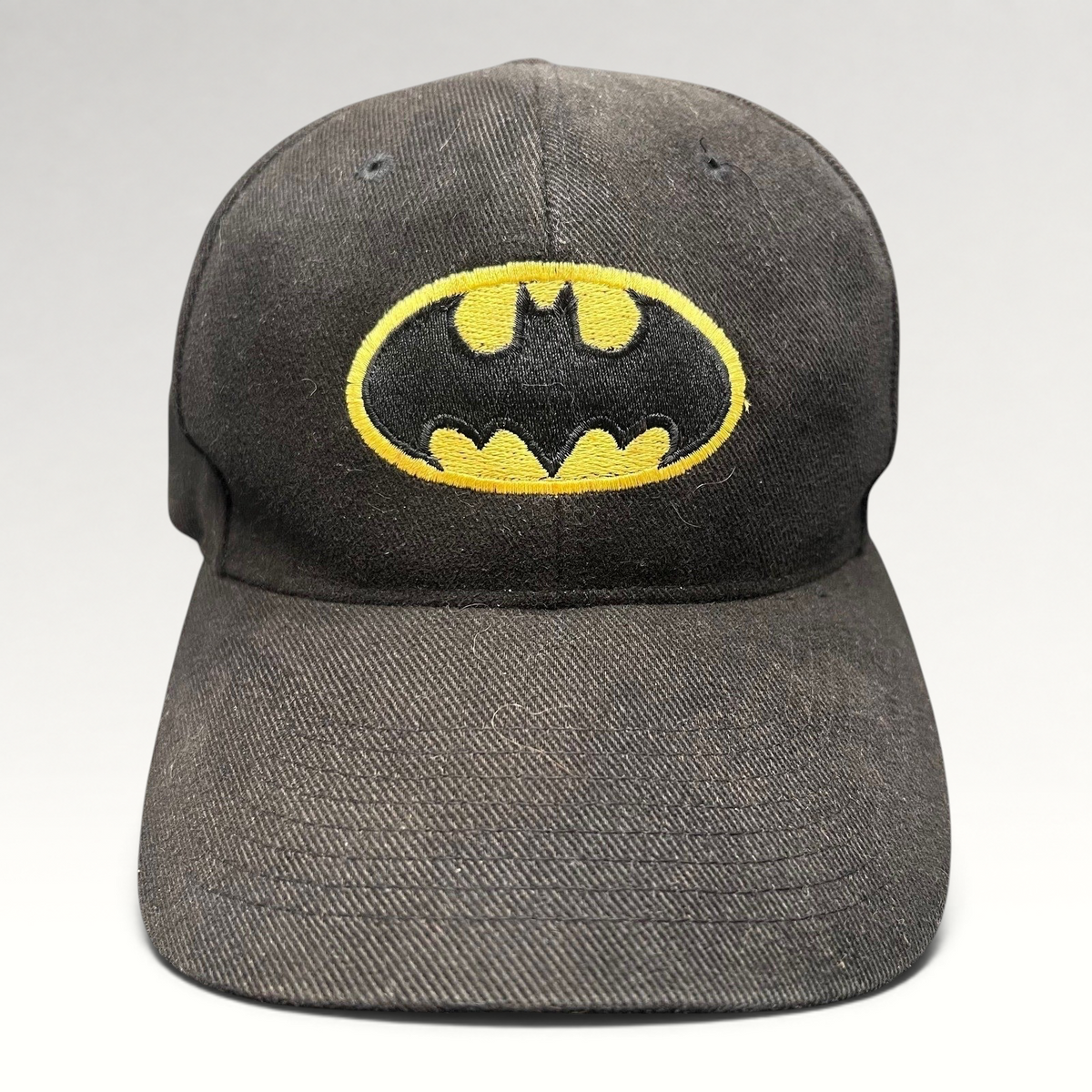 Raree Finds vintage black Batman strapback hat with embroidered yellow and black comic book logo on the front crown