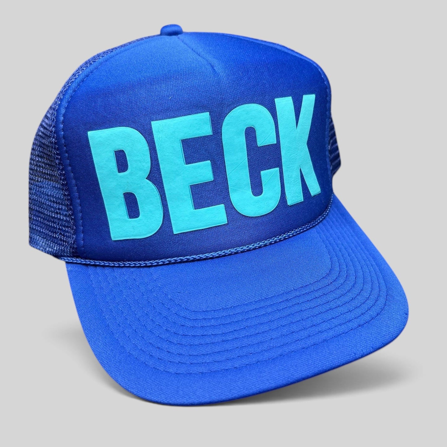 Raree Finds vintage royal blue Otto trucker hat with teal BECK graphic, foam front, and mesh back.