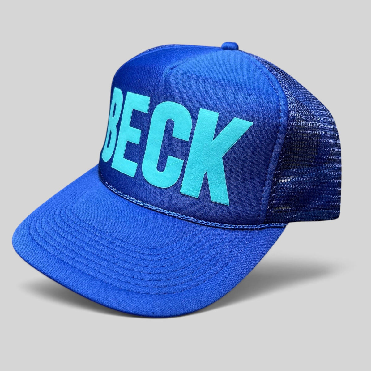 Raree Finds vintage royal blue Otto trucker hat with teal BECK graphic, foam front, mesh back, and rope brim detail.