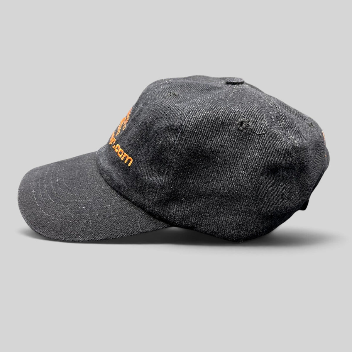 Raree Finds vintage black cotton strapback hat with orange FilmBazaar.com logo embroidery, side profile view.
