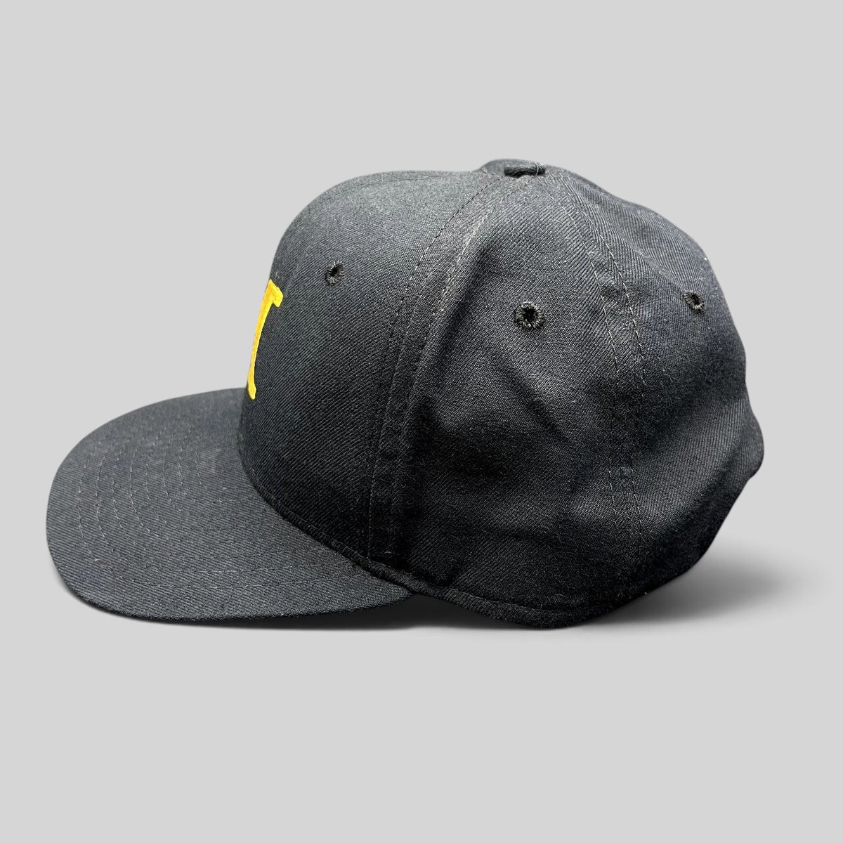 Raree Finds vintage New Era black snapback hat with gold M embroidery and structured crown, side profile view.