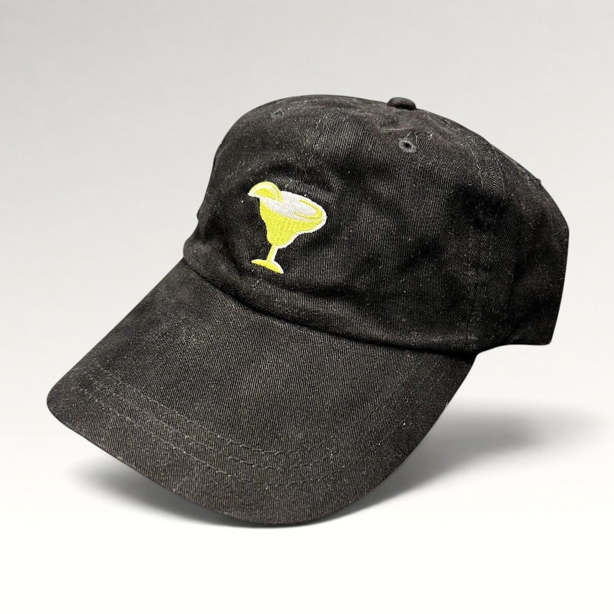 Raree Finds vintage black cotton strapback hat featuring an embroidered yellow margarita glass logo on the front.