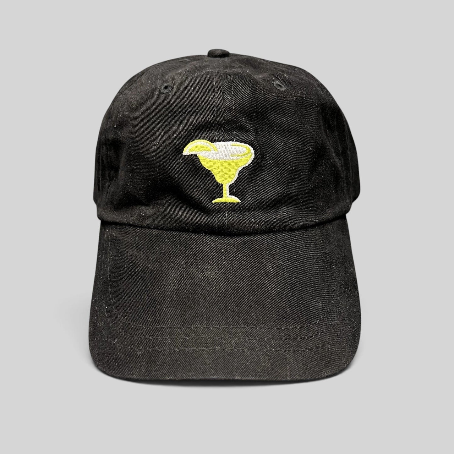 Raree Finds vintage black cotton strapback hat with an embroidered yellow margarita glass logo on the front.