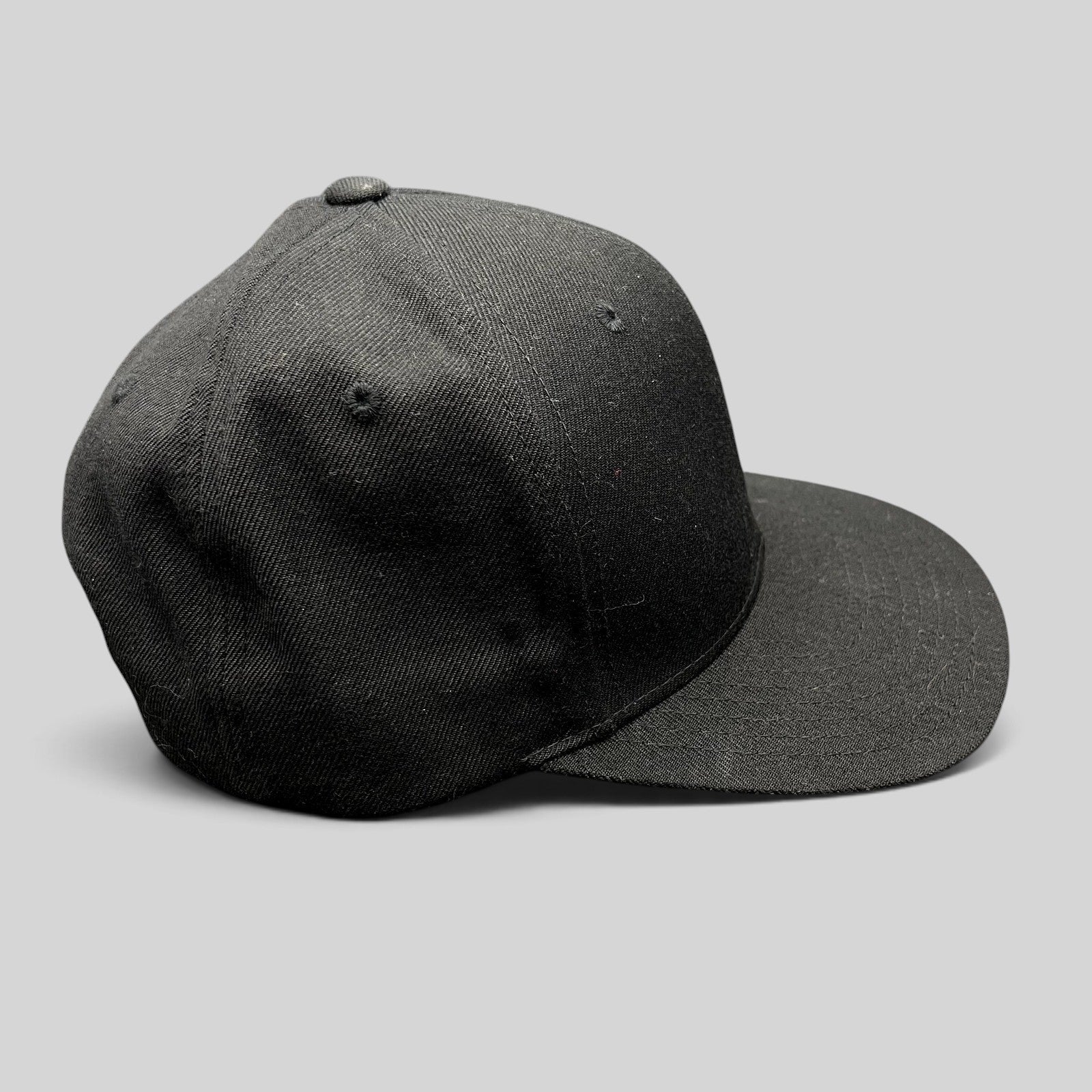 Raree Finds vintage black Yupoong snapback hat with a structured high-profile crown and classic green undervisor.