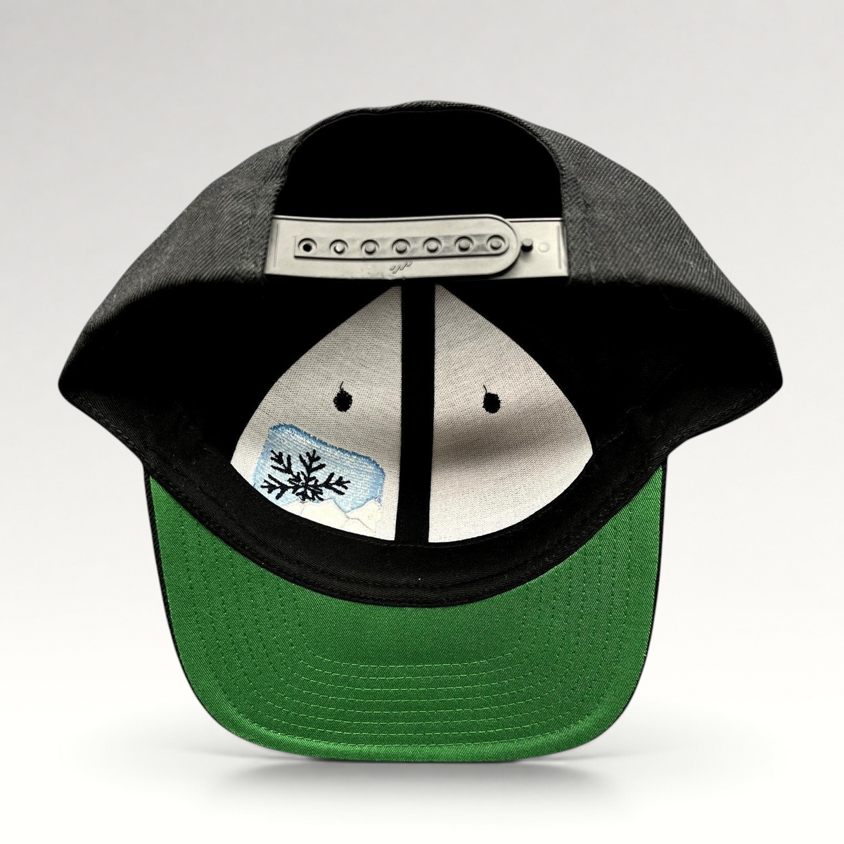Raree Finds vintage black Yupoong snapback hat with green undervisor and embroidered mountain snowflake logo interior