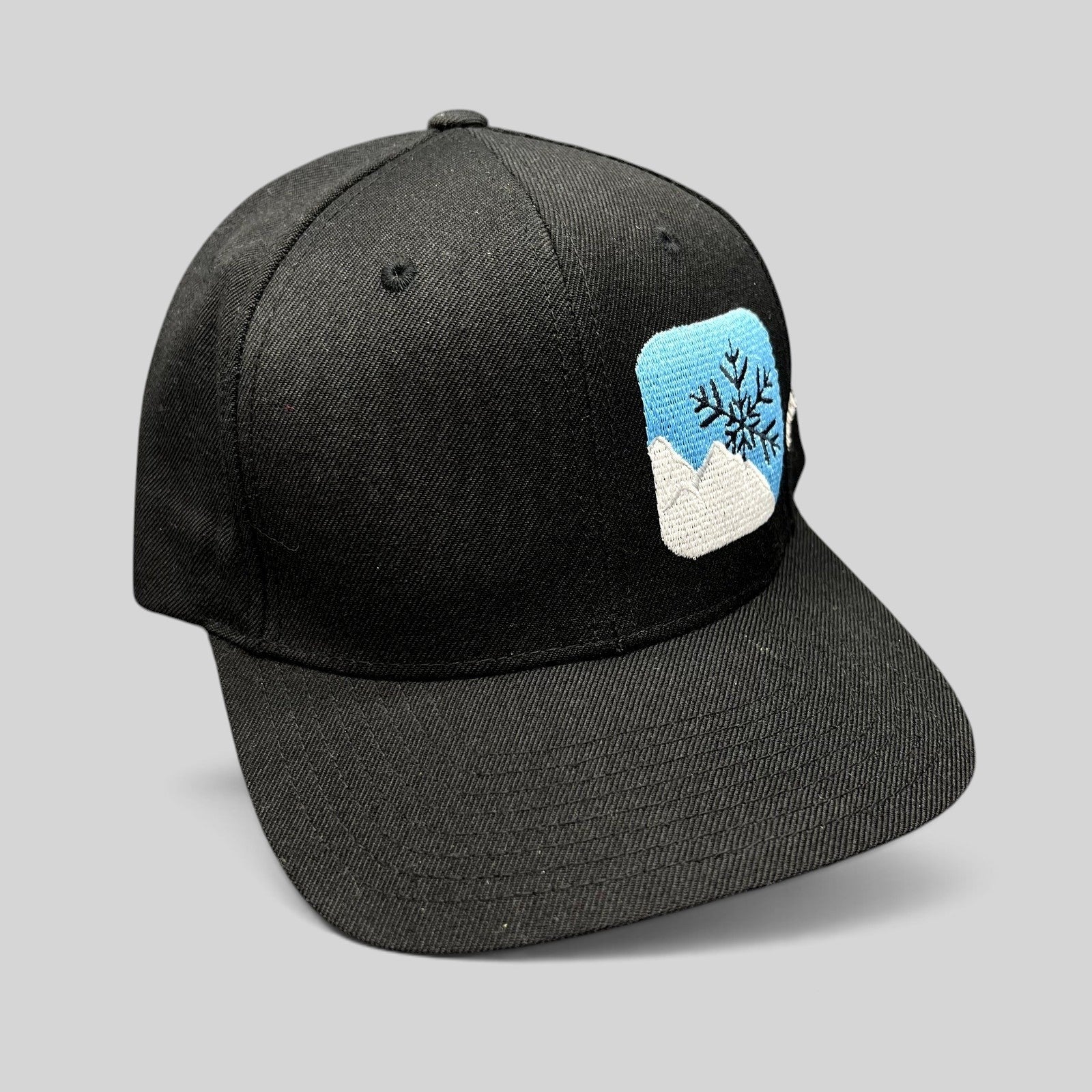 Raree Finds vintage black Yupoong snapback hat with embroidered mountain and snowflake logo and green undervisor