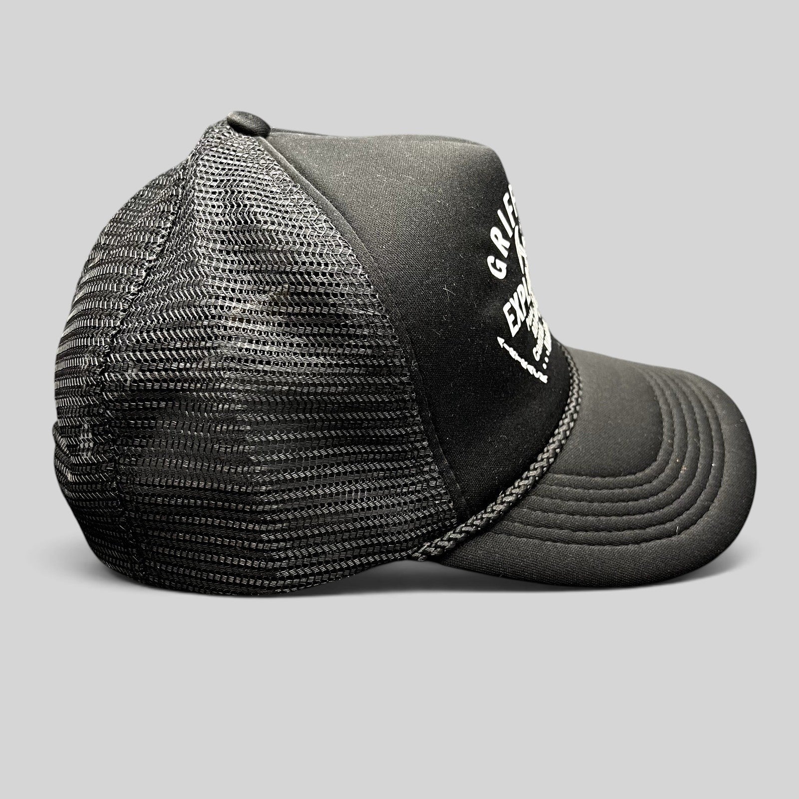 Raree Finds vintage black foam trucker hat with white Griffith Exploration mining graphic and braided brim detail.