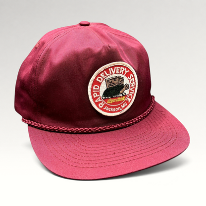 Raree Finds vintage burgundy trucker hat with a Rapid Delivery Service embroidered patch and braided rope brim detail.
