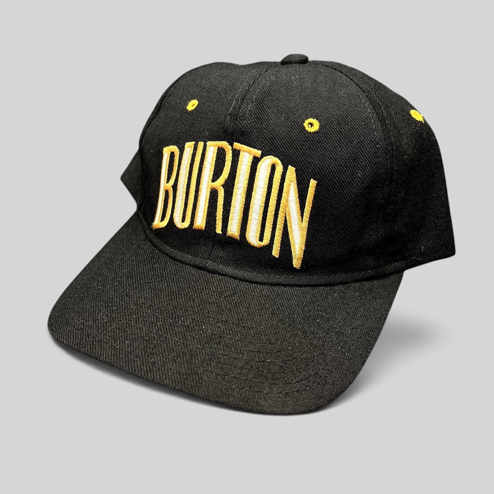 Raree Finds vintage Burton Snowboards snapback hat in black with gold embroidered lettering and structured design.
