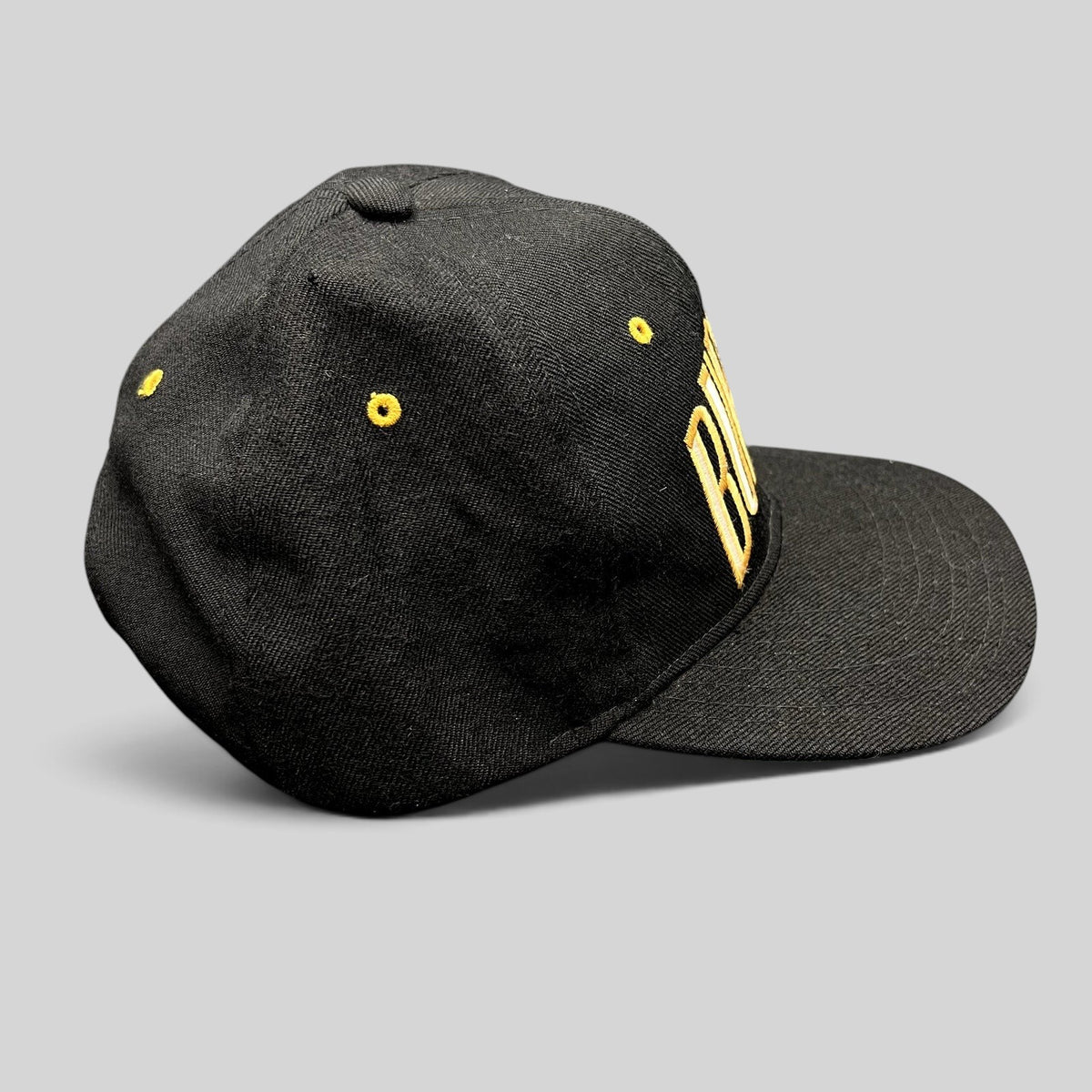 Raree Finds vintage black Burton Snowboards snapback hat with gold embroidered lettering and yellow eyelets