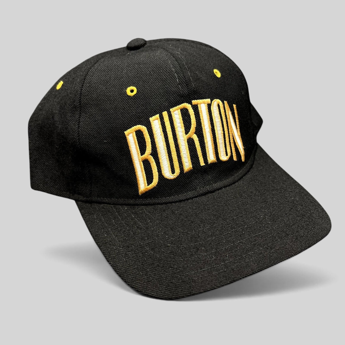 Raree Finds vintage black Burton Snowboards snapback hat with gold and white embroidered lettering