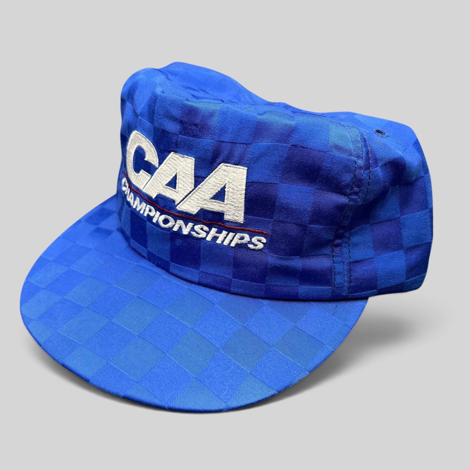 Raree Finds vintage royal blue checkered CAA Championships snapback hat with white embroidered lettering and flat bill.