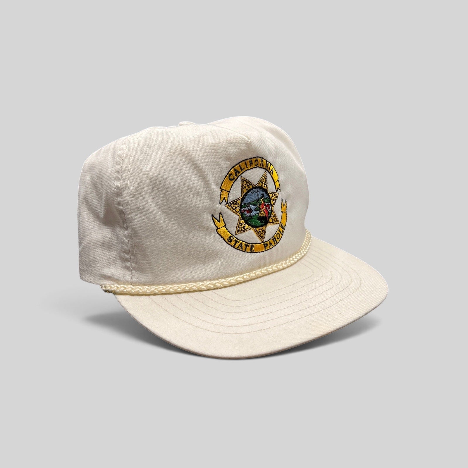 Raree Finds vintage 90s white Otto snapback hat featuring an embroidered California State Parole emblem and rope trim.
