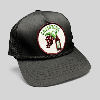 Raree Finds vintage black Calistoga Wine trucker hat with embroidered grape and wine bottle patch and braided rope