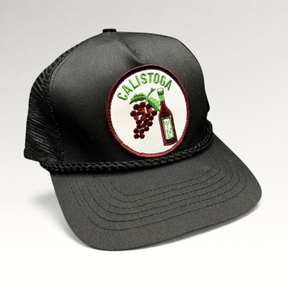 Raree Finds vintage black trucker hat with Calistoga wine bottle and grape patch, foam front, and braided rope brim.