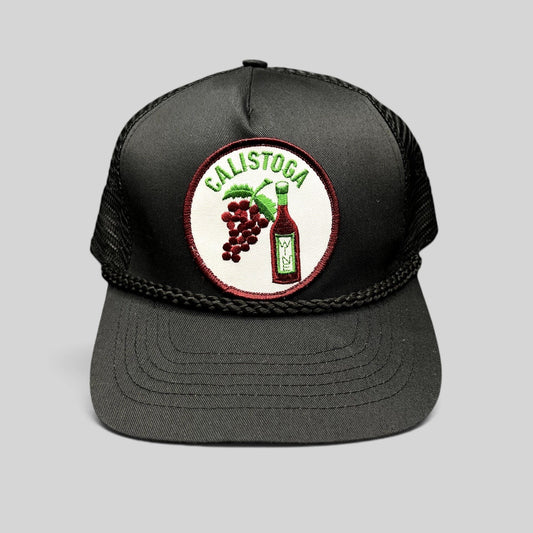 Raree Finds vintage black Calistoga Wine trucker hat with embroidered grape and bottle patch and braided rope brim